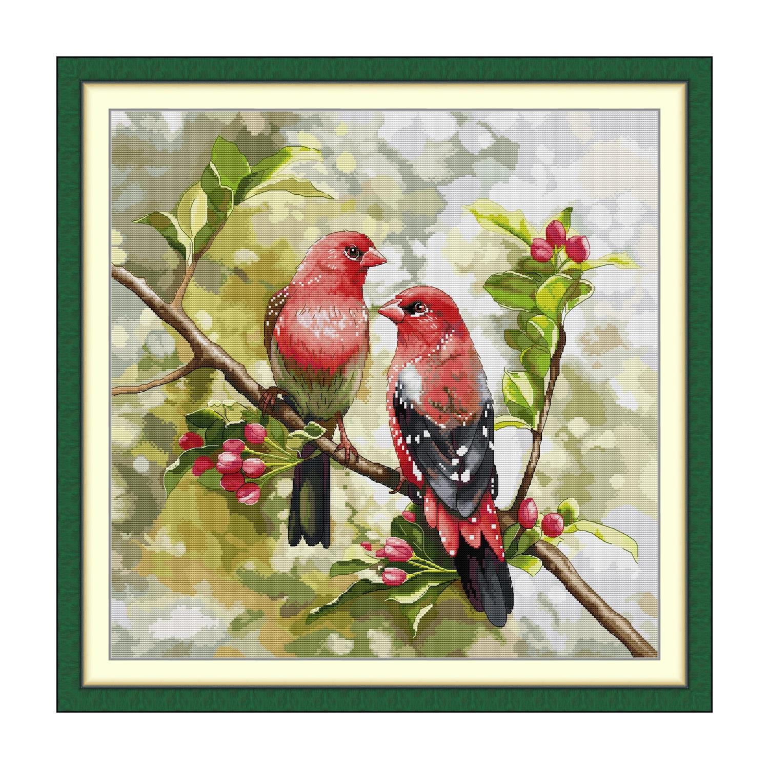 Bird cross stitch design of two red birds perched on a berry branch with green leaves