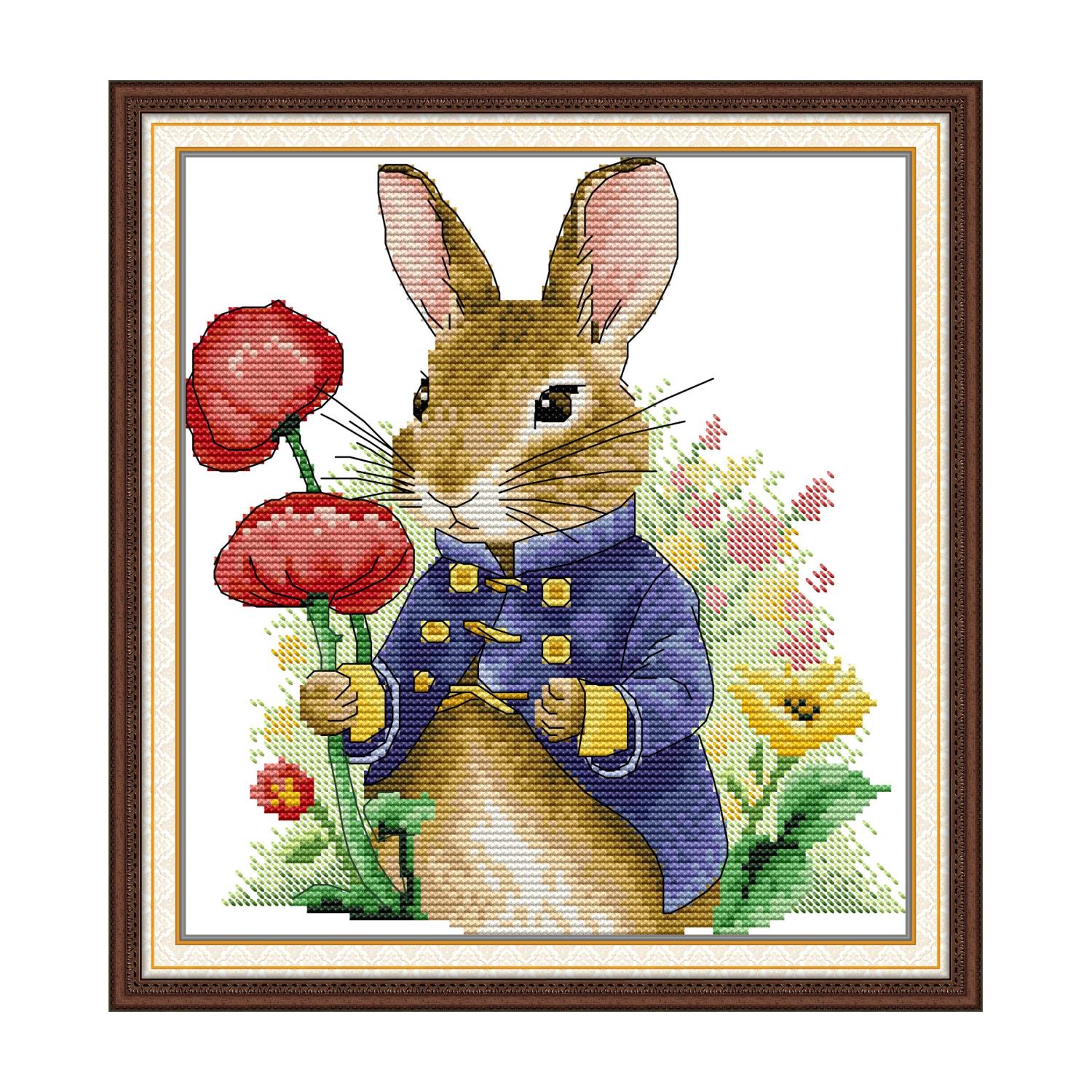 Rabbit cross stitch design of a rabbit in a blue coat holding red poppy flowers