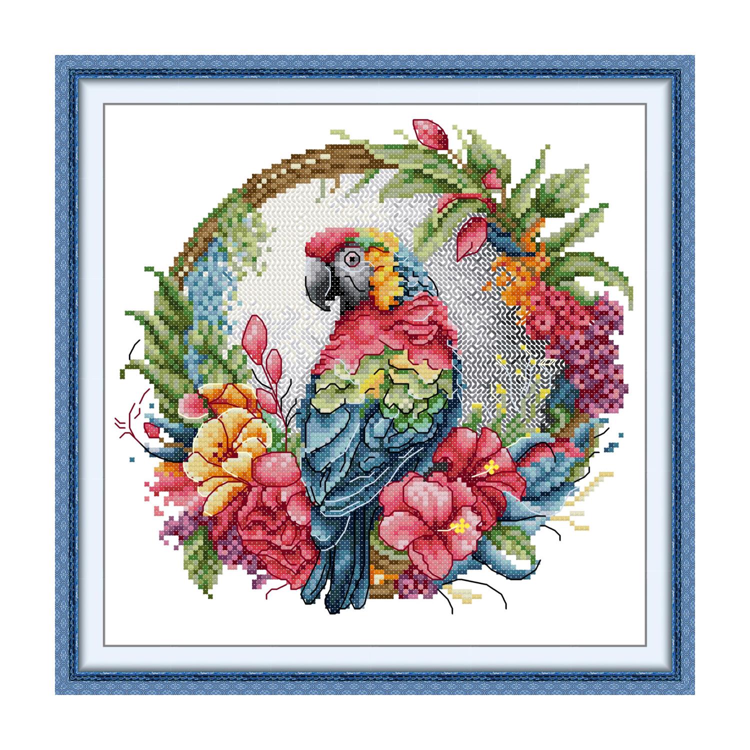 Floral cross stitch design of a glowing pink flower with butterflies on a deep blue background