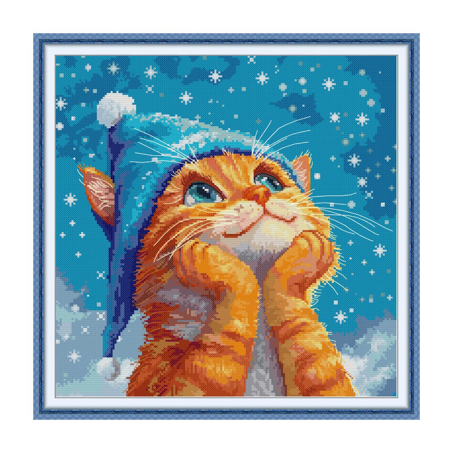 Cat cross stitch design of an orange cat wearing a blue knitted winter hat with snow and snowflakes