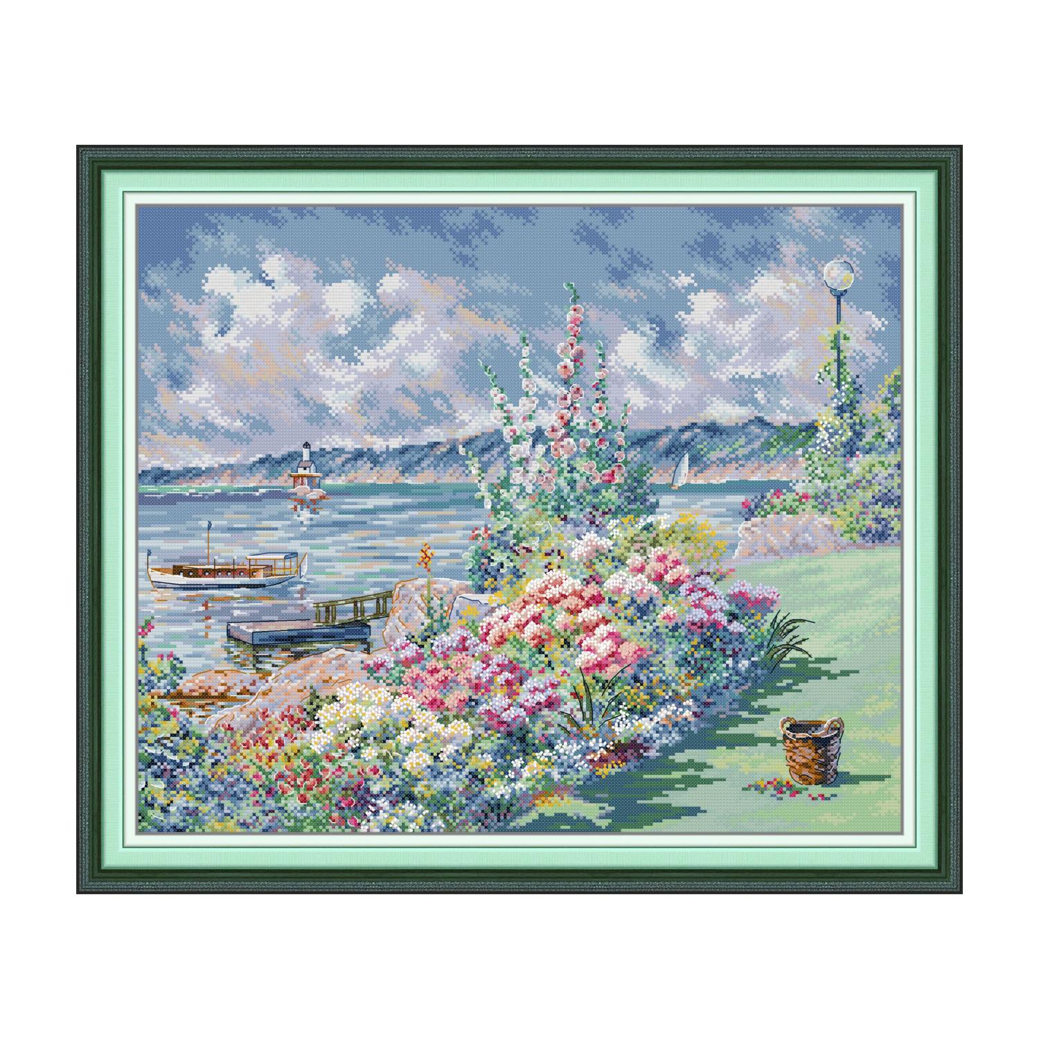 Landscape cross stitch design of blooming hollyhocks along a coast with a boat, lighthouse, and flower basket