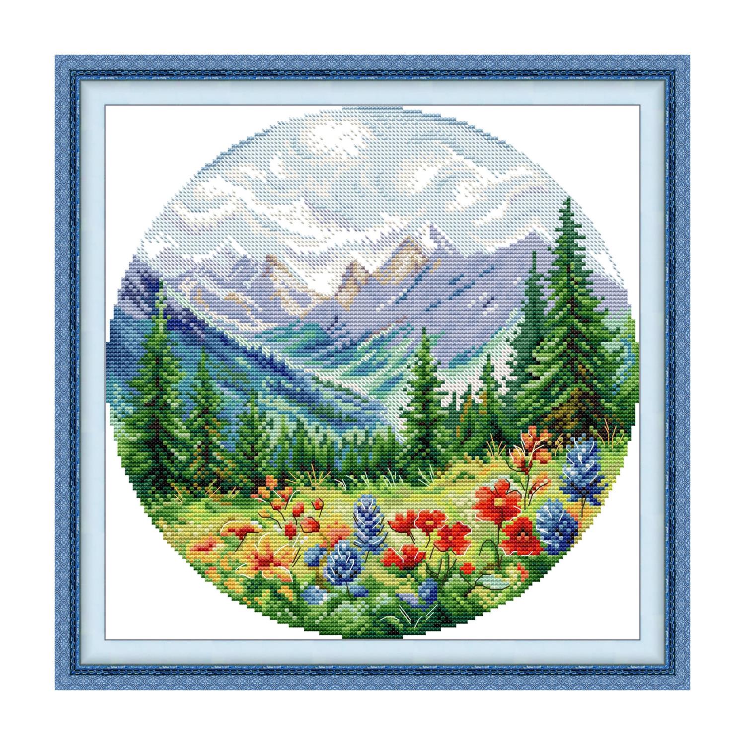 Landscape cross stitch design of wildflowers and snow-capped mountains with pine trees, in a round composition